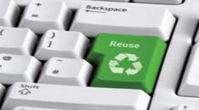 A keyboard that is showing the return button with a green key and the recycle symbol to show re-using of material