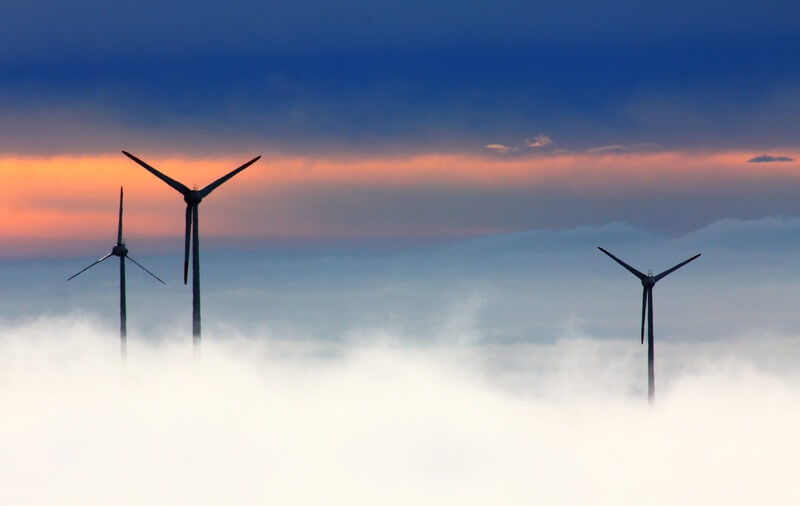Wind turbines emerging from fog